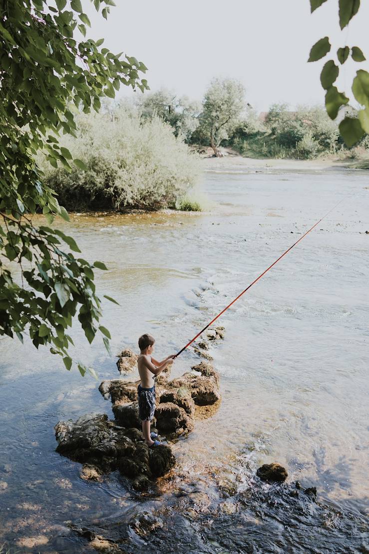 Kid fishing in a river - Slovenia © Viktor Pravdica/stock.adobe.com